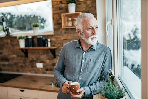 Blasser, ausgedürrter, &auml;lterer Herr, der aus dem Fenster blickt